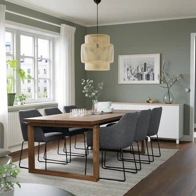 Oak dining table with six grey chairs in a bright dining room